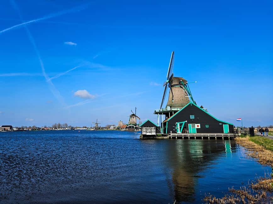 Amsterdam: Zaanse Schans windmills & Volendam Guided Tour - Volendam: churches, the fish-auction atmosphere, and dike views over IJssel lake
